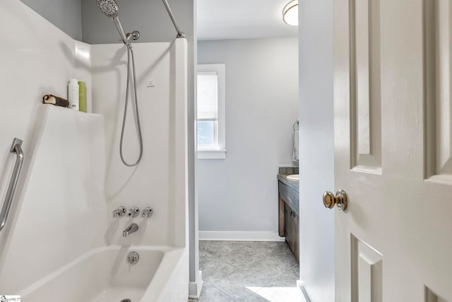 bathroom featuring tile patterned flooring, baseboards, shower / washtub combination, and vanity