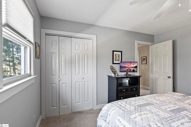 bedroom with a closet, carpet flooring, a ceiling fan, and baseboards