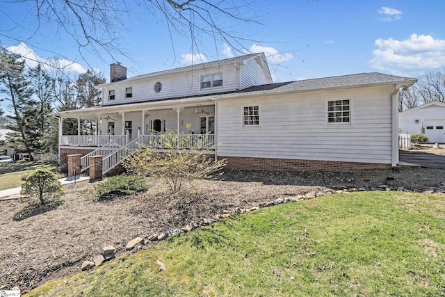 rear view of house with a chimney, a porch, a lawn, stairway, and ceiling fan