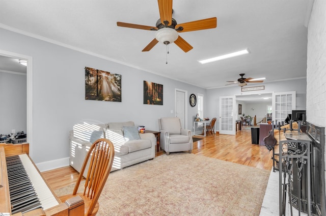 living room with french doors, crown molding, baseboards, and wood finished floors