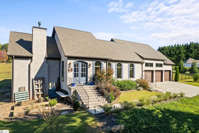 view of front of home featuring concrete driveway, a chimney, roof with shingles, an attached garage, and brick siding