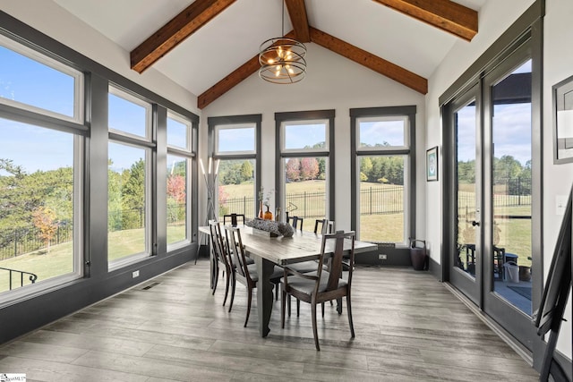 sunroom with vaulted ceiling with beams, visible vents, and a chandelier