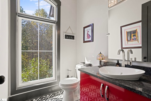 bathroom featuring toilet, plenty of natural light, and vanity