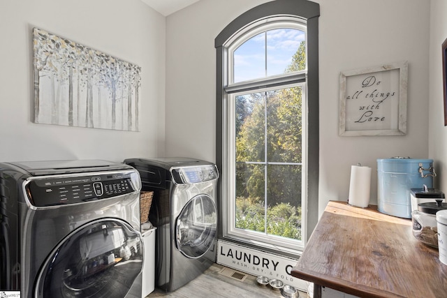 washroom featuring laundry area, plenty of natural light, wood finished floors, and independent washer and dryer