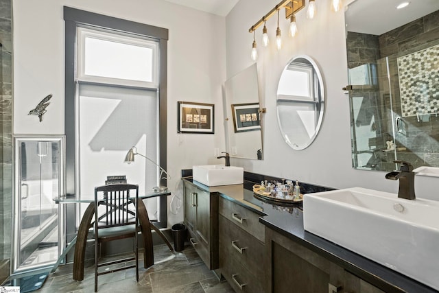 bathroom featuring a stall shower, a sink, and a wealth of natural light