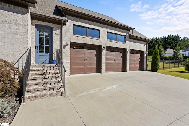 garage with driveway and fence