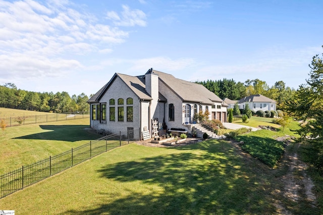 back of house featuring fence and a lawn