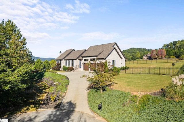 view of front of property with a front yard, concrete driveway, and fence