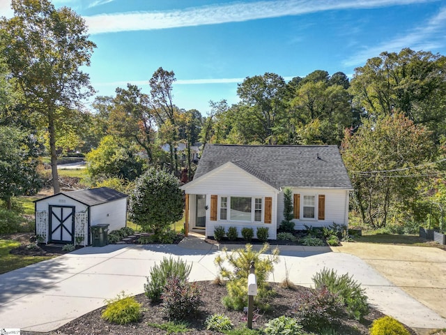 view of front of house with a storage unit, an outdoor structure, and a shingled roof