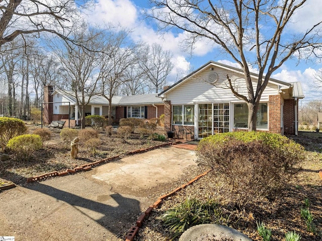 view of front of property featuring brick siding and a sunroom