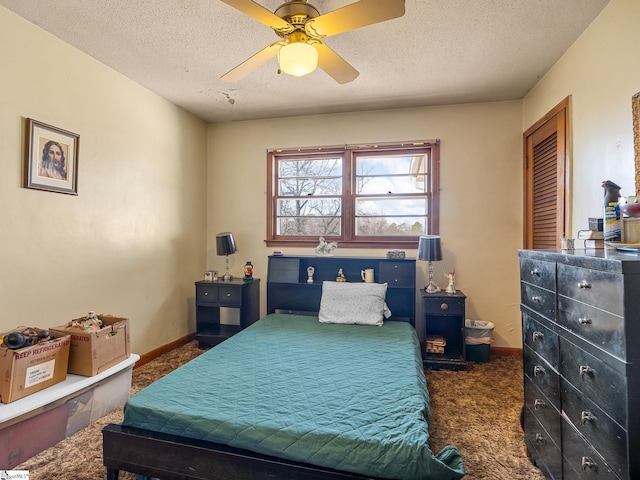 bedroom with ceiling fan, baseboards, dark colored carpet, and a textured ceiling