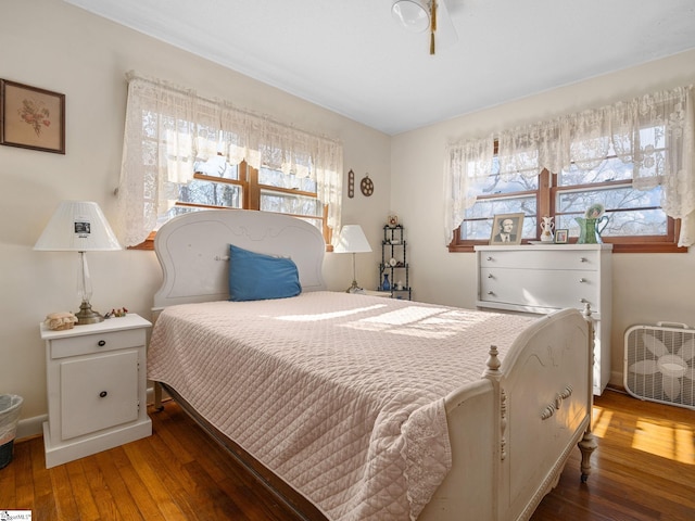 bedroom with multiple windows and wood-type flooring