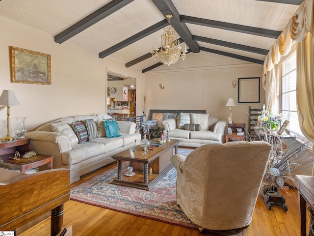 living area featuring lofted ceiling with beams, hardwood / wood-style flooring, and a notable chandelier