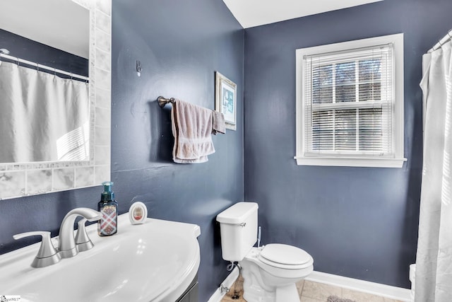 full bath featuring baseboards, toilet, a shower with curtain, tile patterned floors, and a sink