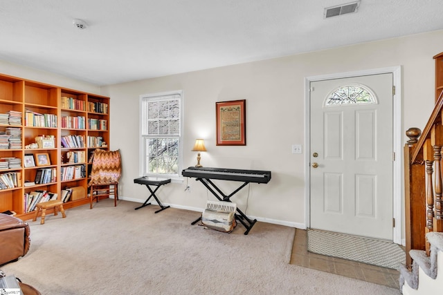 carpeted entrance foyer featuring visible vents and baseboards