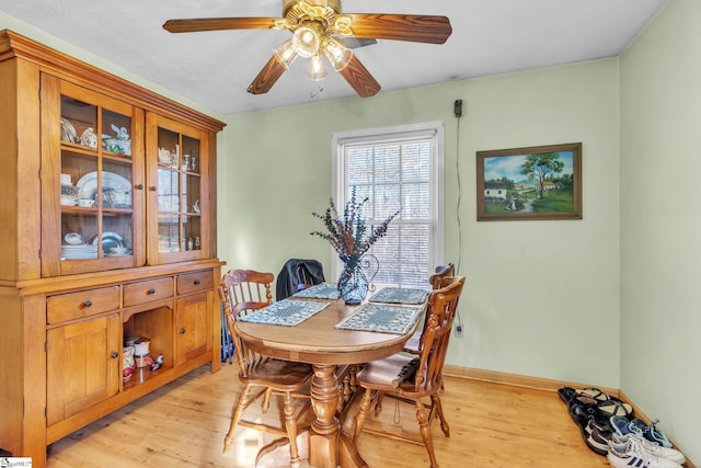 dining room featuring light wood-type flooring, ceiling fan, and baseboards