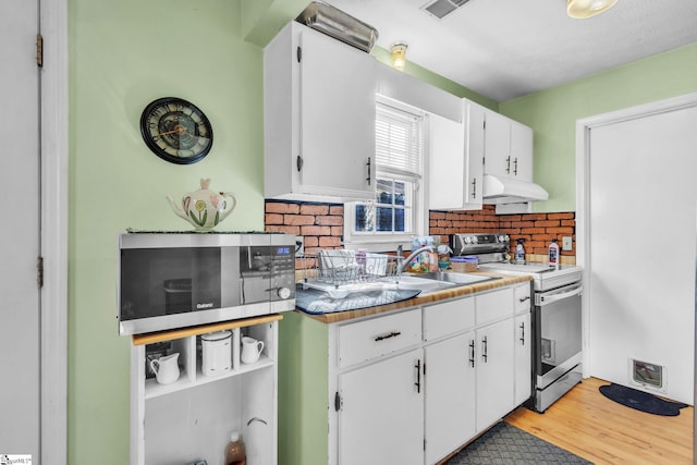 kitchen featuring stainless steel appliances, visible vents, white cabinets, and under cabinet range hood