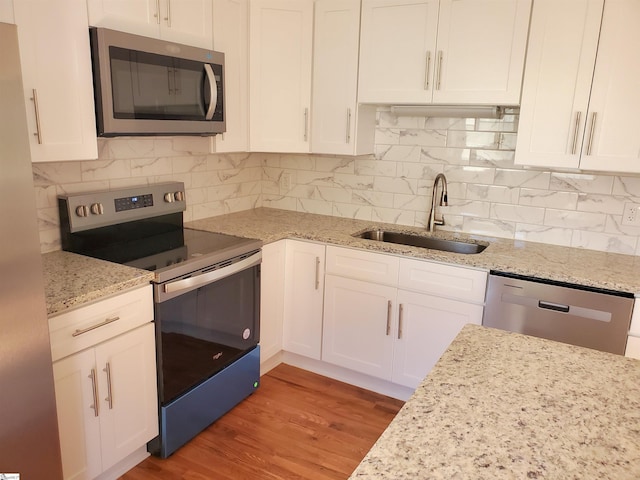 kitchen with white cabinetry, stainless steel appliances, and a sink