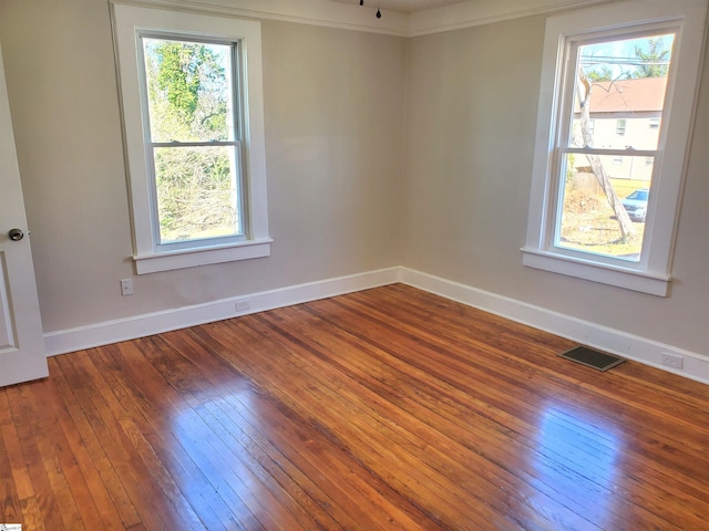 spare room with a healthy amount of sunlight, visible vents, and baseboards