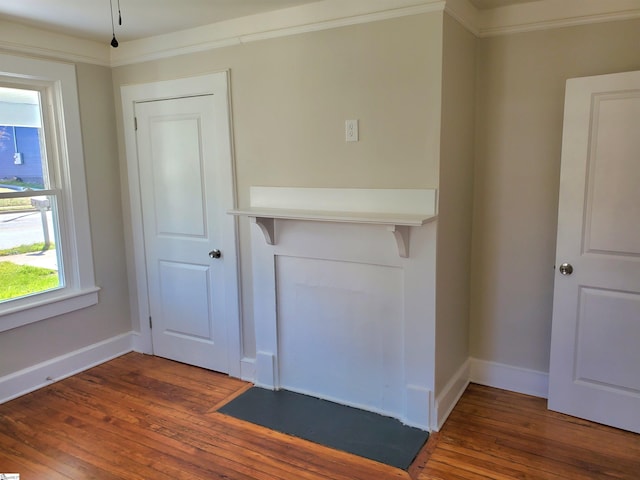 unfurnished living room with hardwood / wood-style flooring and baseboards