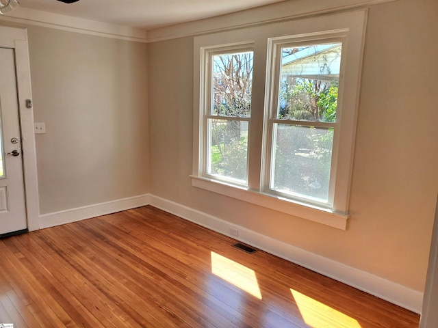 spare room with baseboards, visible vents, and light wood-style floors