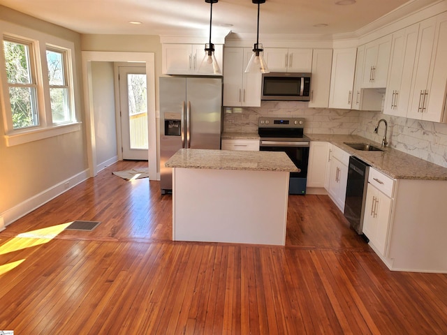 kitchen with backsplash, a kitchen island, stainless steel appliances, and a sink