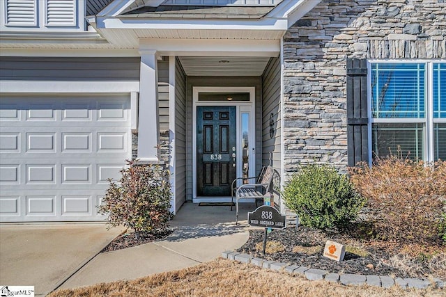 doorway to property with stone siding and an attached garage