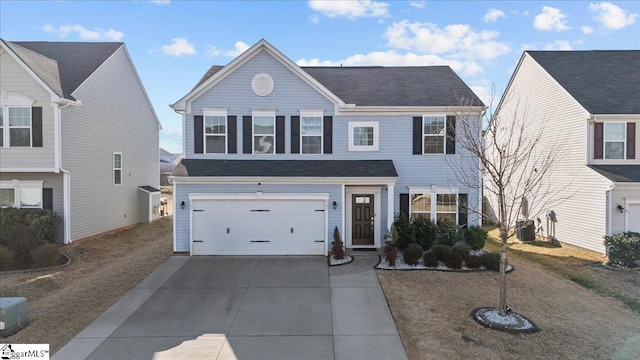 view of front of home with concrete driveway, central AC, and an attached garage