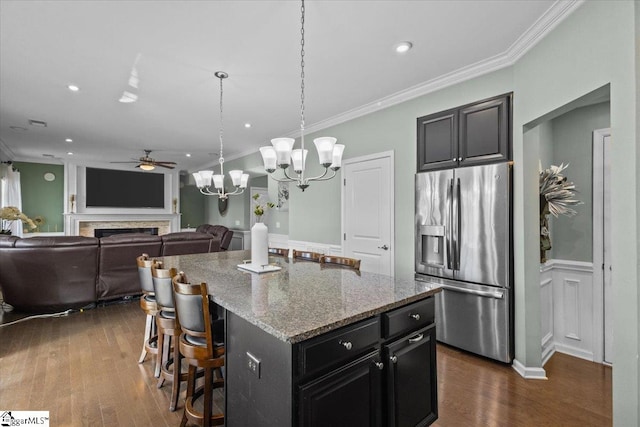 kitchen featuring ornamental molding, a fireplace, and stainless steel refrigerator with ice dispenser