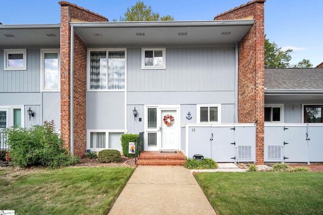 view of property featuring a chimney, a front yard, and fence