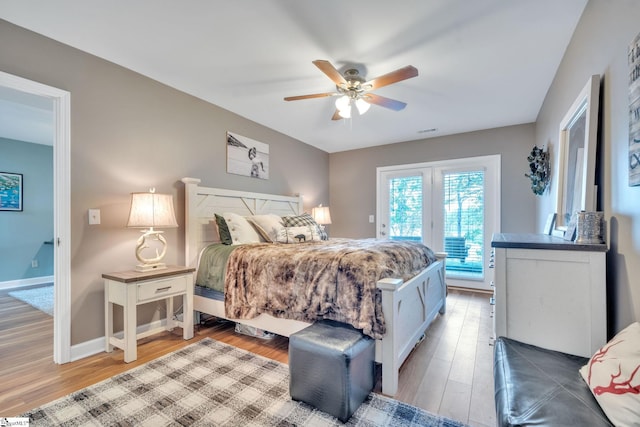 bedroom with light wood finished floors, visible vents, a ceiling fan, access to outside, and baseboards