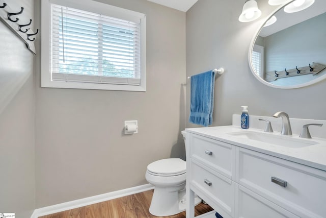 bathroom featuring vanity, wood finished floors, toilet, and baseboards