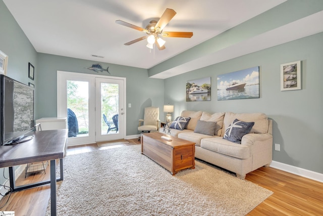 living room featuring visible vents, ceiling fan, baseboards, and wood finished floors