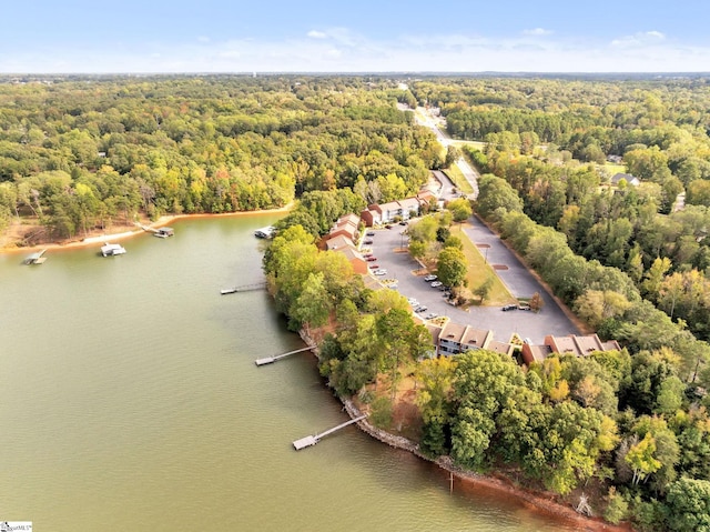 birds eye view of property with a water view and a wooded view