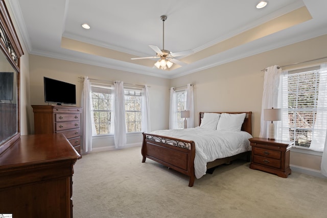 bedroom featuring light carpet, baseboards, a raised ceiling, and crown molding