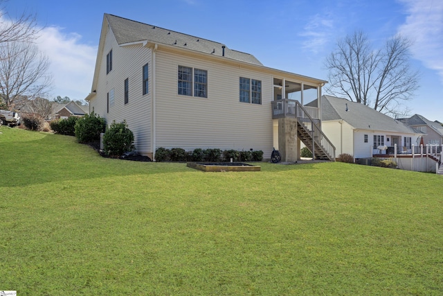 rear view of property featuring a yard and stairs