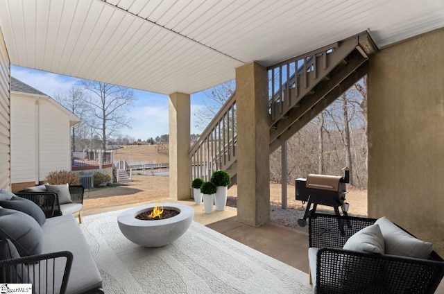 view of patio / terrace featuring stairs and an outdoor fire pit