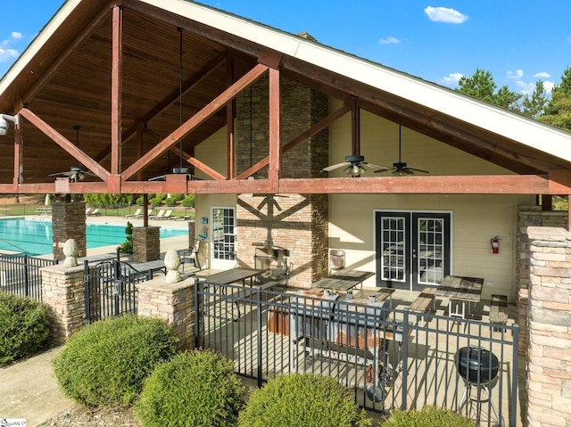 view of patio / terrace with ceiling fan, a community pool, fence, and french doors