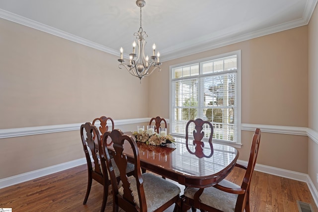 dining area featuring baseboards, visible vents, and wood finished floors