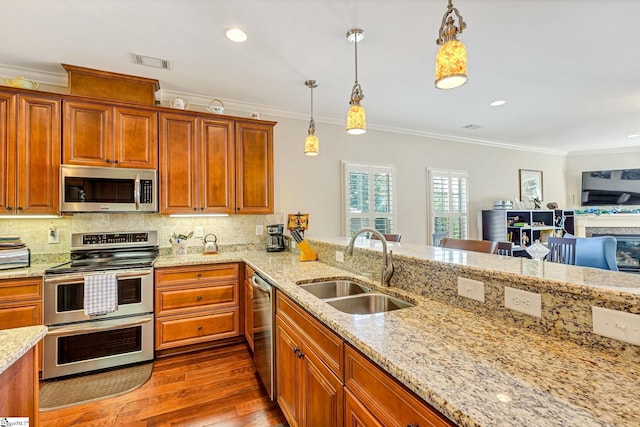 kitchen with dark wood-style floors, backsplash, appliances with stainless steel finishes, ornamental molding, and a sink