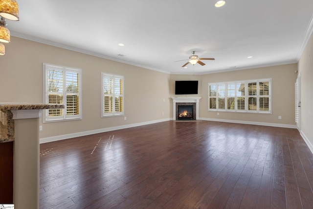 unfurnished living room featuring ornamental molding, plenty of natural light, dark wood finished floors, and a high end fireplace