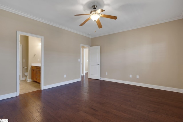 unfurnished bedroom featuring hardwood / wood-style flooring, connected bathroom, baseboards, and crown molding