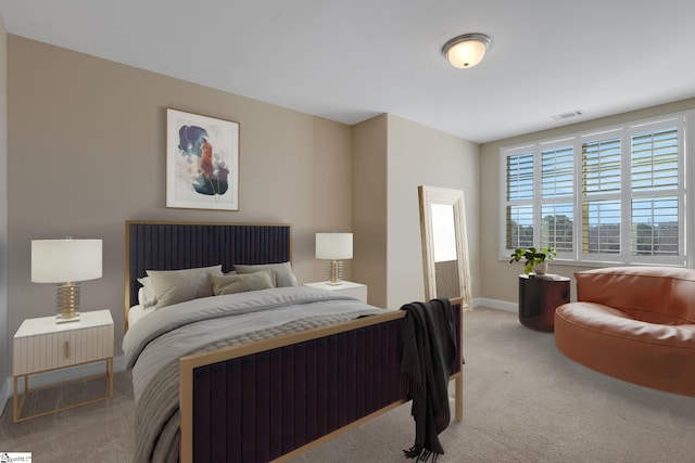 bedroom with light carpet, visible vents, and baseboards