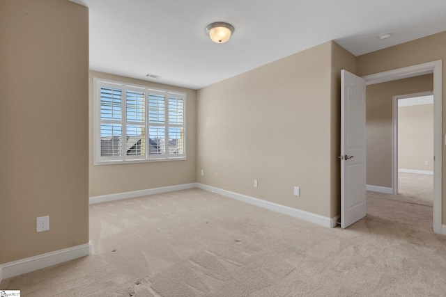 empty room featuring carpet flooring, visible vents, and baseboards