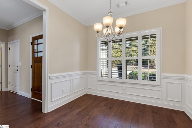 unfurnished dining area featuring dark wood-type flooring, visible vents, ornamental molding, wainscoting, and an inviting chandelier