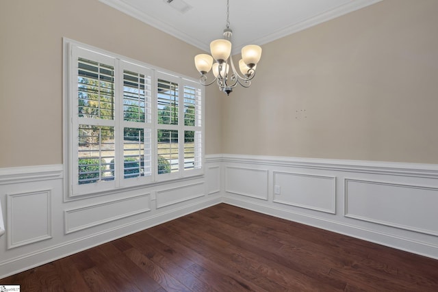 spare room with a notable chandelier, a wainscoted wall, dark wood-style flooring, visible vents, and crown molding