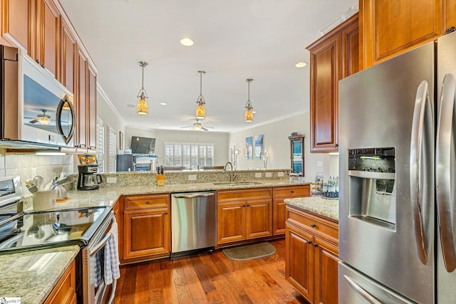 kitchen featuring appliances with stainless steel finishes, dark wood finished floors, a sink, and ornamental molding