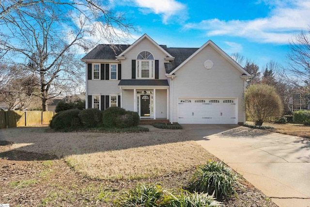 view of front of house with a garage, driveway, and fence