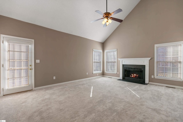 unfurnished living room with a healthy amount of sunlight, a fireplace with flush hearth, and carpet flooring