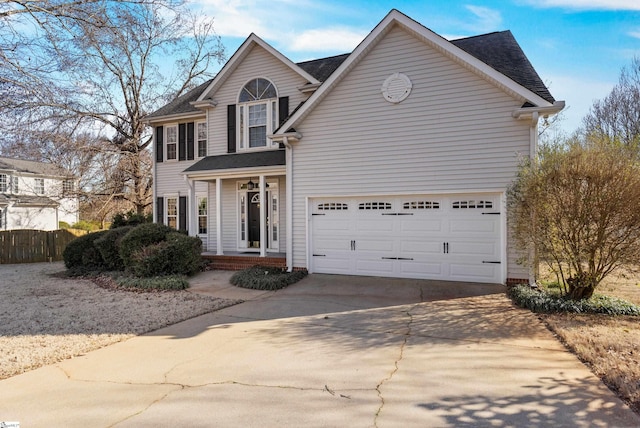 traditional-style house featuring driveway and fence